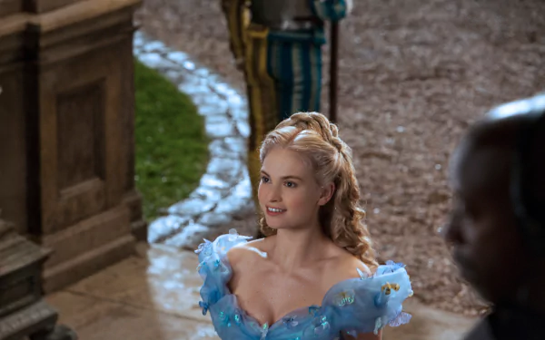 Woman in a shimmering blue Cinderella-style ballgown on stone steps, a scene from the movie Cinderella (2015). 5K Ultra HD PC desktop wallpaper.