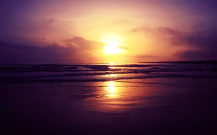 HD PC desktop wallpaper of a tranquil beach at sunset, featuring a glowing sun reflecting on calm waters under a vibrant purple and orange sky.