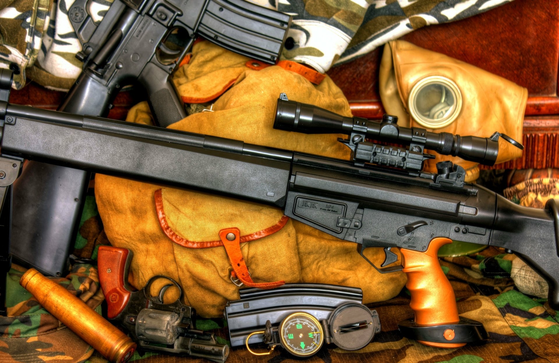 4K Ultra HD PC desktop wallpaper depicting man-made rifles and assorted tactical gear laid across canvas bags and camouflage fabric.