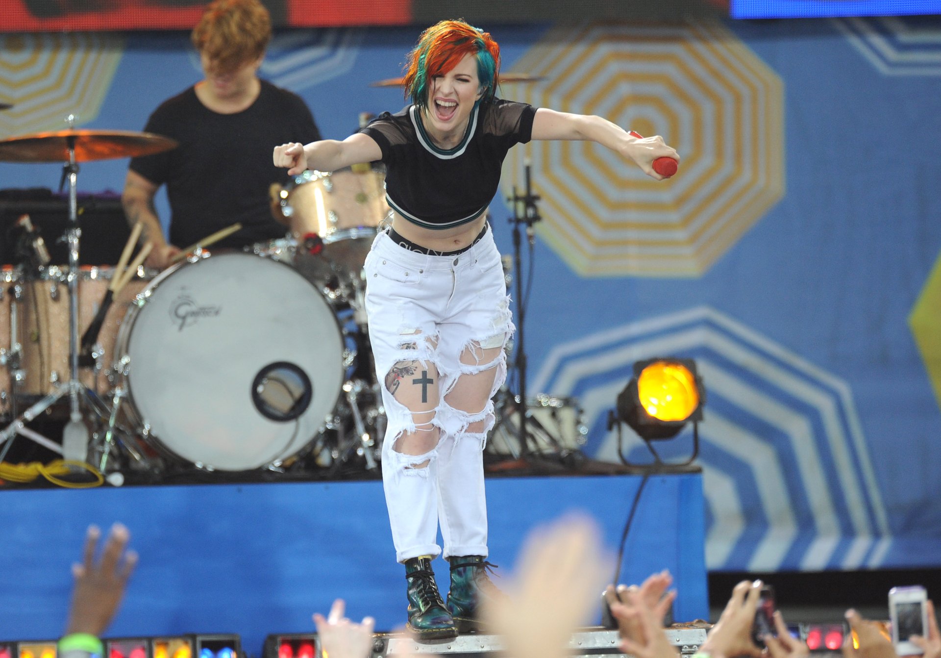 Music-themed 4K Ultra HD PC desktop wallpaper: orange-haired female rock singer leaping onstage, drummer behind her and cheering crowd in foreground.