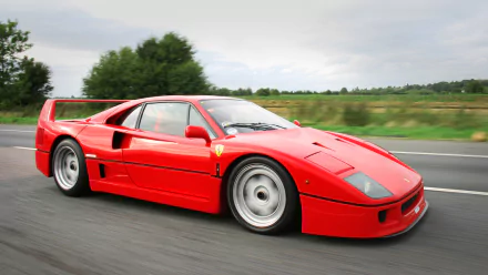 Red Ferrari F40 vehicle speeding along a country road — HD PC desktop wallpaper and background.
