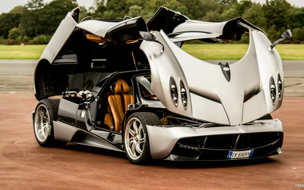 A stunning Pagani Huayra showcases its unique design with butterfly doors open, gleaming in high-definition. This image makes a striking desktop wallpaper and background.
