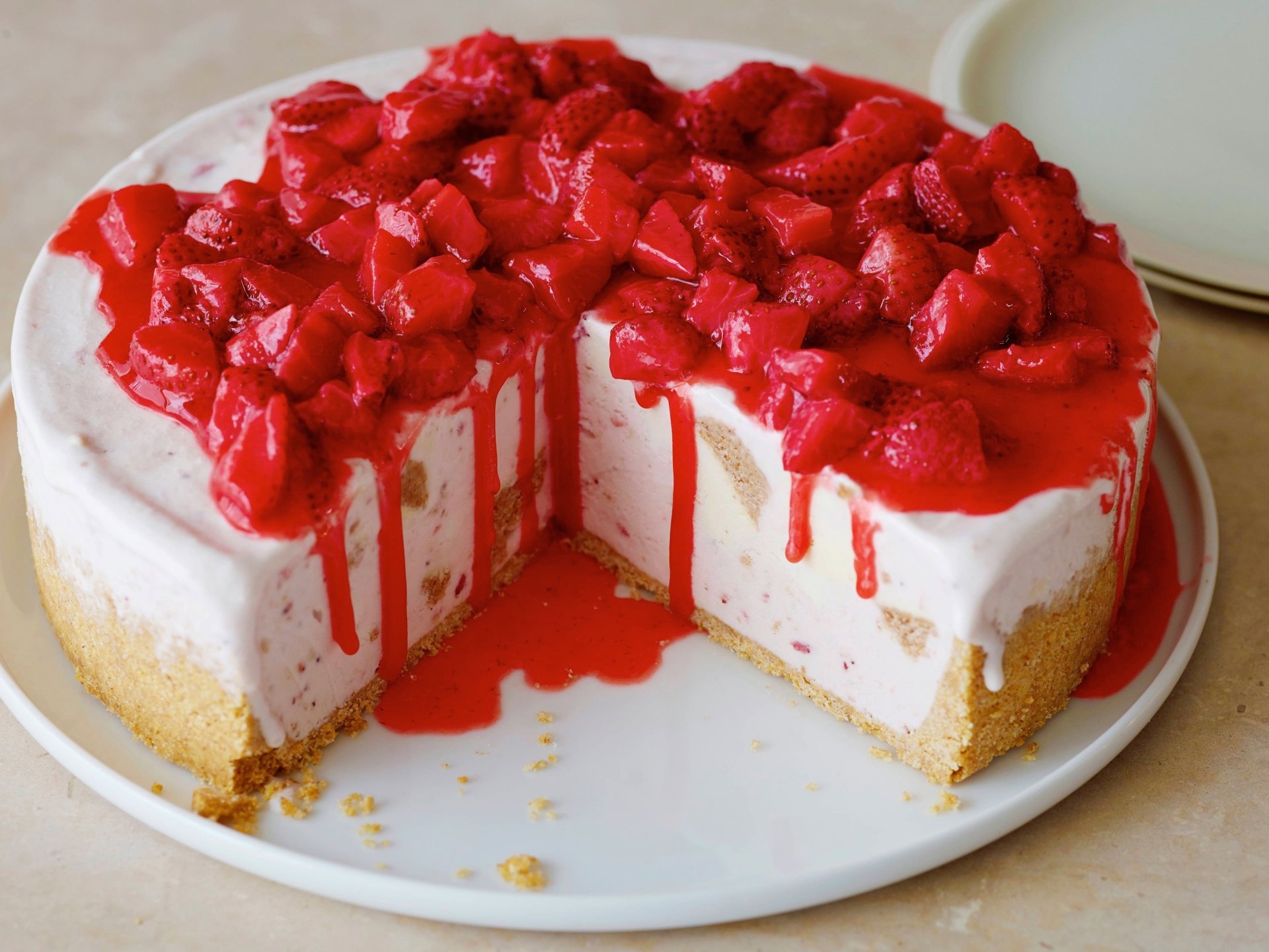 4K Ultra HD PC desktop wallpaper and background: strawberry cheesecake with glossy chopped berries and red sauce, a slice removed revealing creamy filling and graham crust.