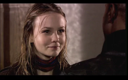 HD desktop wallpaper featuring Carey Mulligan in a scene from the TV show Doctor Who (2005), capturing a close-up moment with a softly lit background.