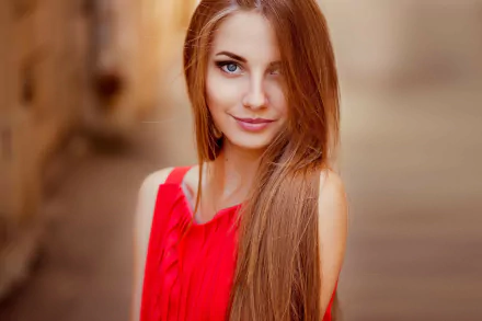 HD desktop wallpaper featuring a woman with long hair and blue eyes, wearing a red top, captured in a soft-focus background.