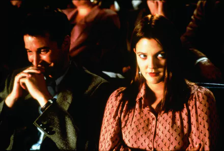 HD desktop wallpaper featuring Drew Barrymore in a scene from the movie Donnie Darko, looking off to the side while sitting next to a man in a theater setting.
