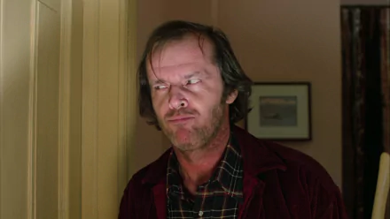 HD PC wallpaper of Jack Torrance from the movie The Shining — deranged, grimacing face peering from a doorway in a dim hotel corridor.