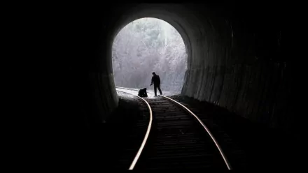 HD PC desktop wallpaper background: tunnel with railroad tracks leading to a bright exit, a silhouetted figure on the tracks — image from the movie Memories of Murder.