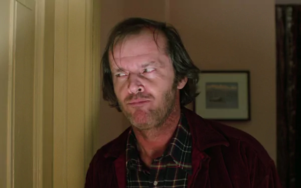 HD PC wallpaper of Jack Torrance from the movie The Shining — deranged, grimacing face peering from a doorway in a dim hotel corridor.