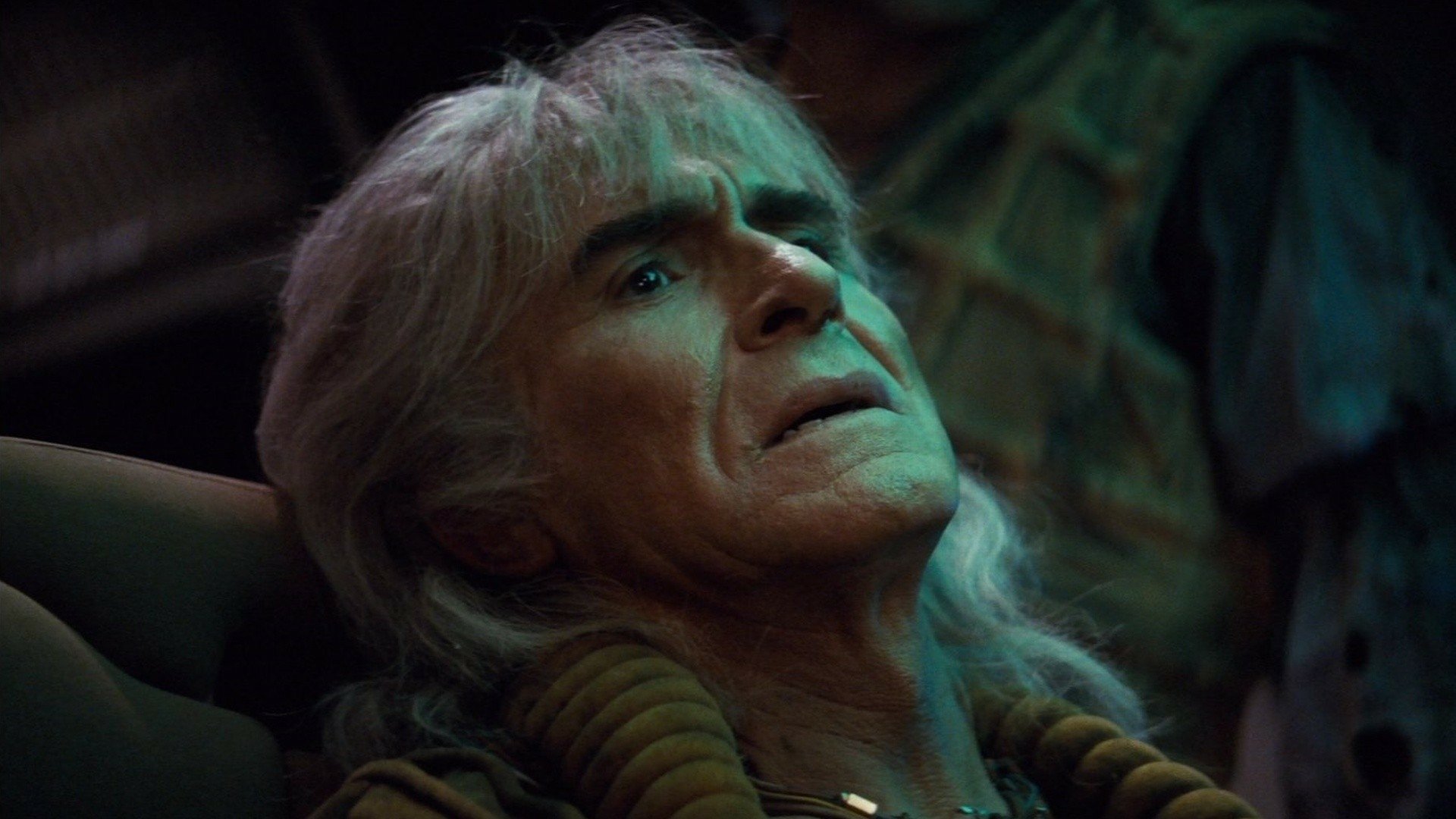 HD desktop wallpaper: close-up of an aging man with long white hair reclining, green-tinted dramatic lighting in a tense moment from Star Trek II: The Wrath of Khan.