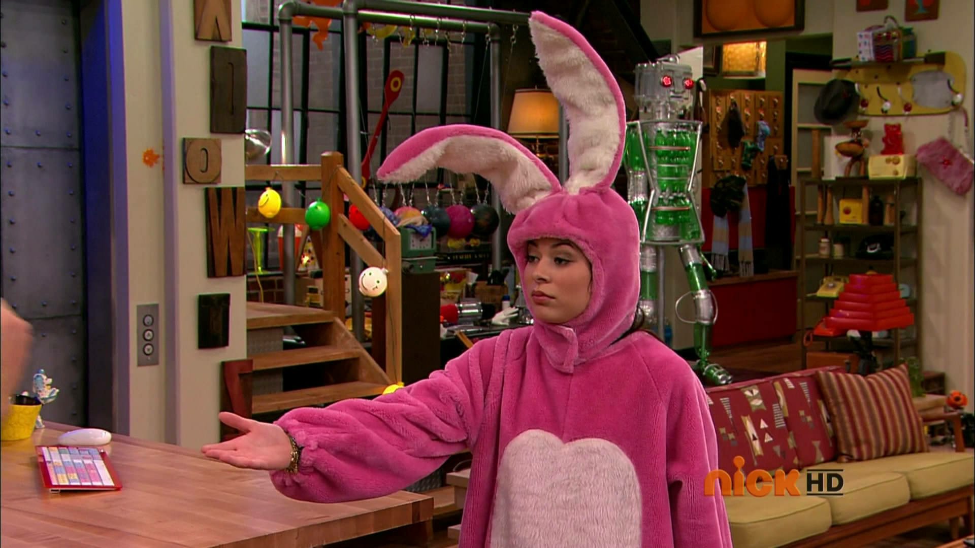 HD PC desktop wallpaper featuring a scene from the TV show iCarly (2007) with a character dressed in a pink bunny costume in a colorful living room setting.