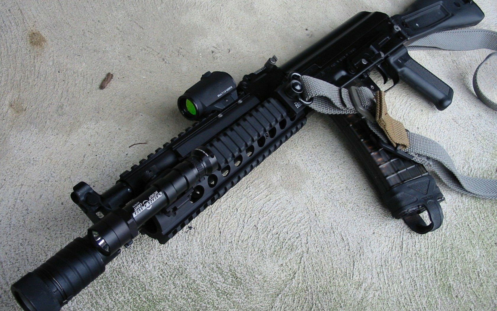 HD desktop wallpaper featuring a close-up of an AK-47 rifle, showcasing its detailed components and tactical accessories.