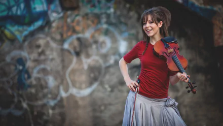 HD PC desktop wallpaper featuring musician Lindsey Stirling holding a violin and smiling against an artistic, graffiti-covered background.