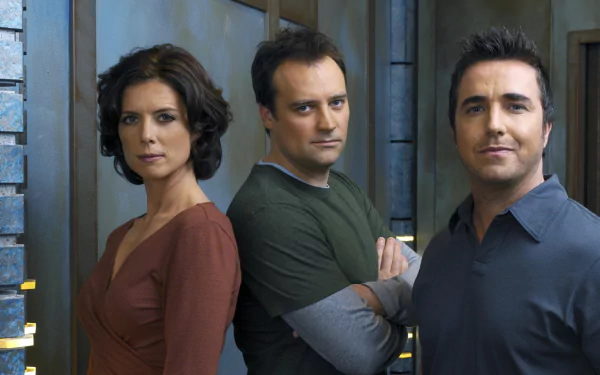 HD PC desktop wallpaper of three characters from the TV show Stargate Atlantis standing in a metallic corridor, facing the camera.