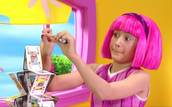 HD PC desktop wallpaper from the TV show LazyTown featuring a young girl with bright pink hair building a house of cards inside a colorful room.