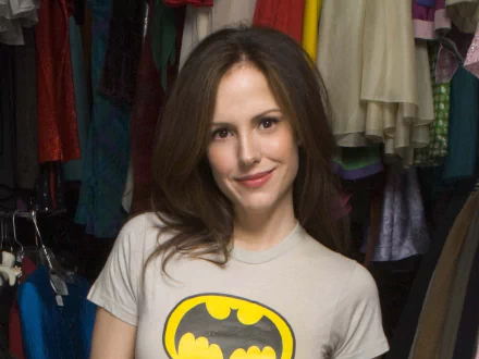 HD PC desktop wallpaper featuring celebrity Mary-Louise Parker smiling in a casual Batman t-shirt with a colorful clothing background.