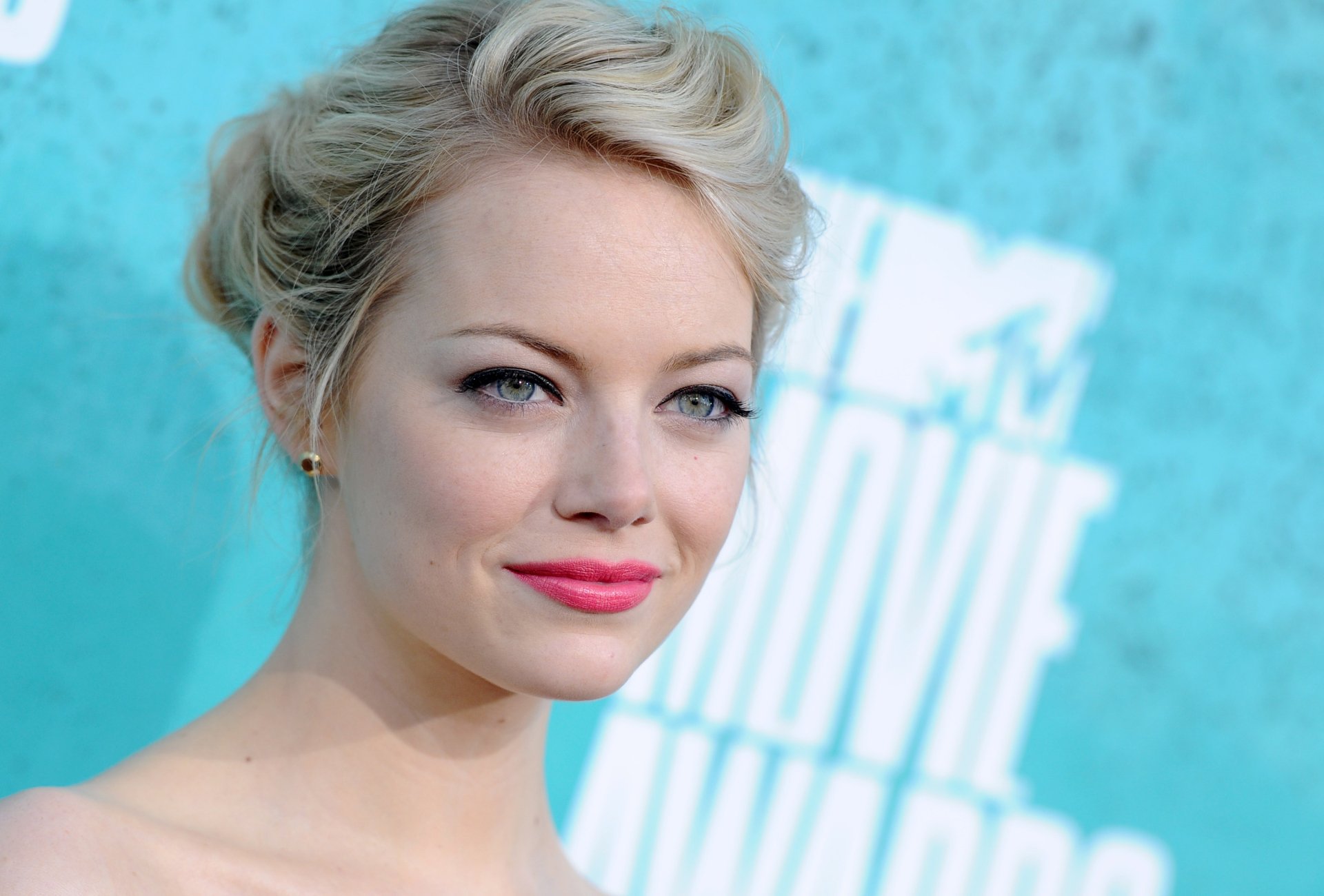 HD PC desktop wallpaper featuring a close-up portrait of celebrity Emma Stone with a soft blue background.