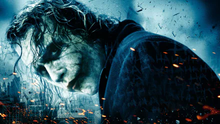 A dramatic HD wallpaper featuring Heath Ledger as the Joker from the movie The Dark Knight, showcasing intense expression amidst a backdrop of chaos and flames.
