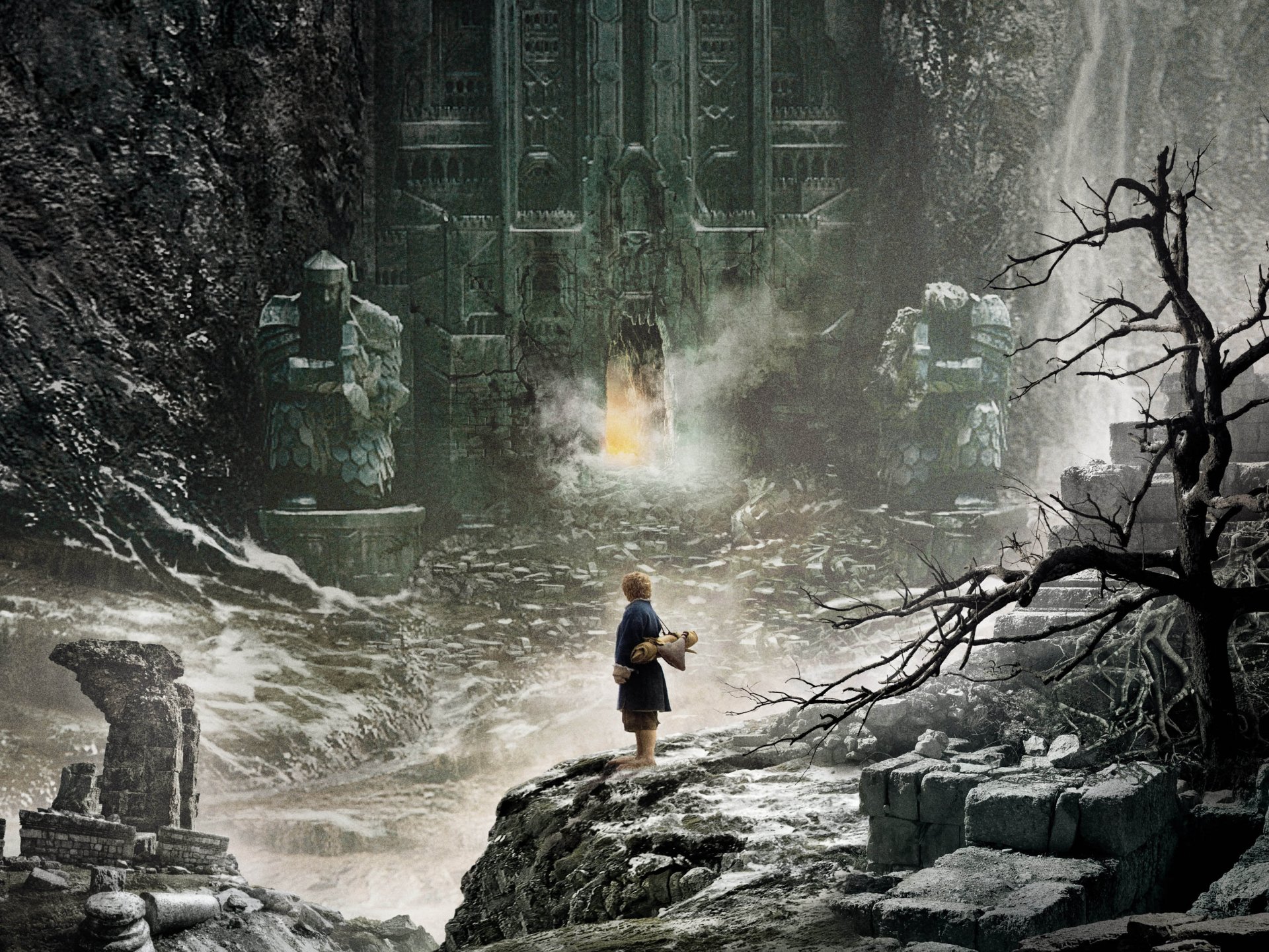 2K Quad HD PC desktop wallpaper from the movie The Hobbit: The Desolation Of Smaug — lone figure approaches an ancient, mist-shrouded mountain gate amid icy ruins and jagged rocks.