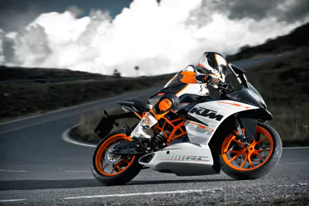 HD desktop wallpaper featuring a sleek KTM motorcycle navigating a winding road, with dramatic clouds in the background. The vibrant orange and black colors accentuate the bike's dynamic design.