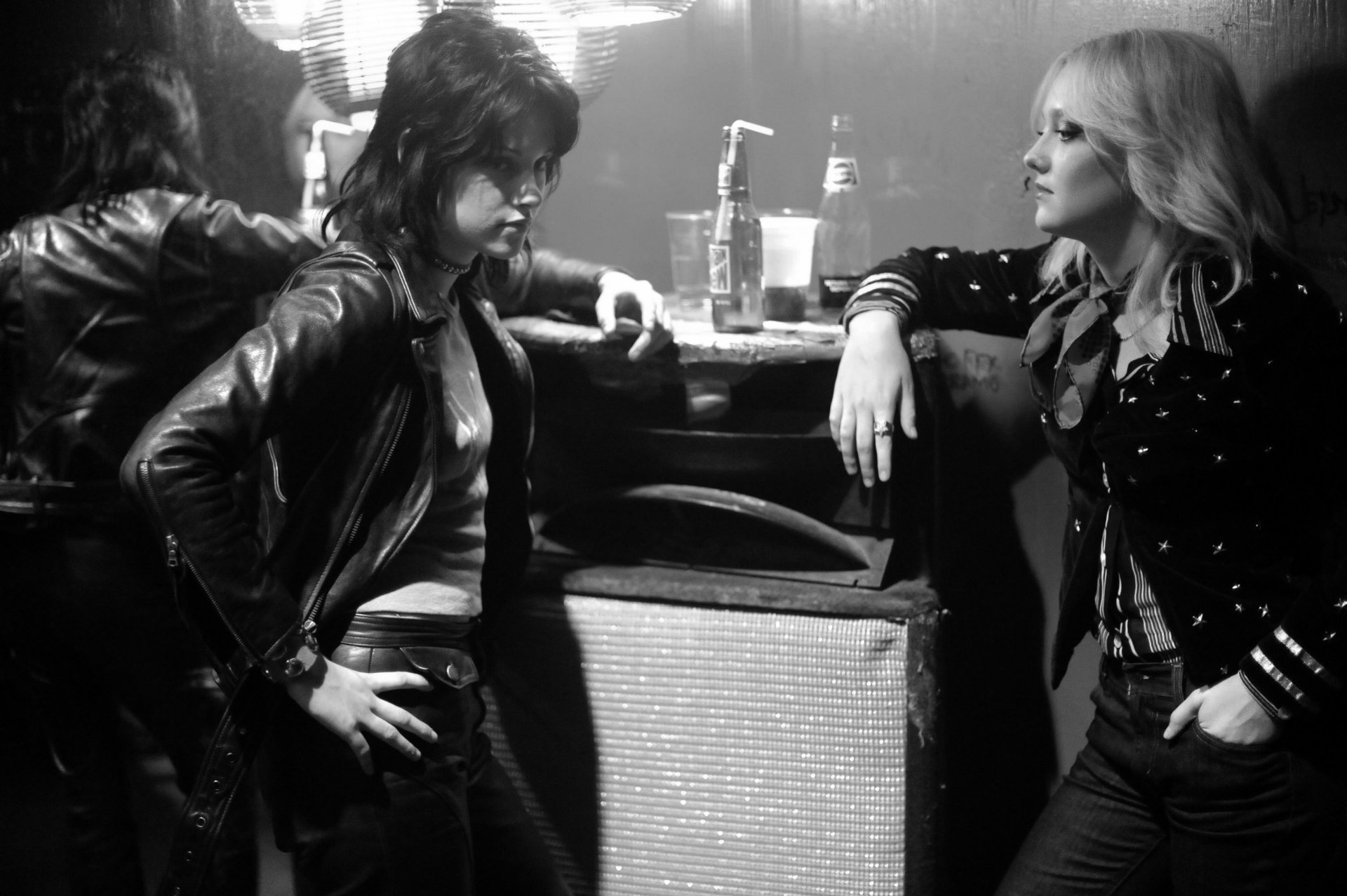 Black and white HD desktop wallpaper from the movie The Runaways, featuring Kristen Stewart and Dakota Fanning in a tense backstage moment.