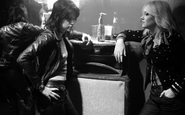 Black and white HD desktop wallpaper from the movie The Runaways, featuring Kristen Stewart and Dakota Fanning in a tense backstage moment.