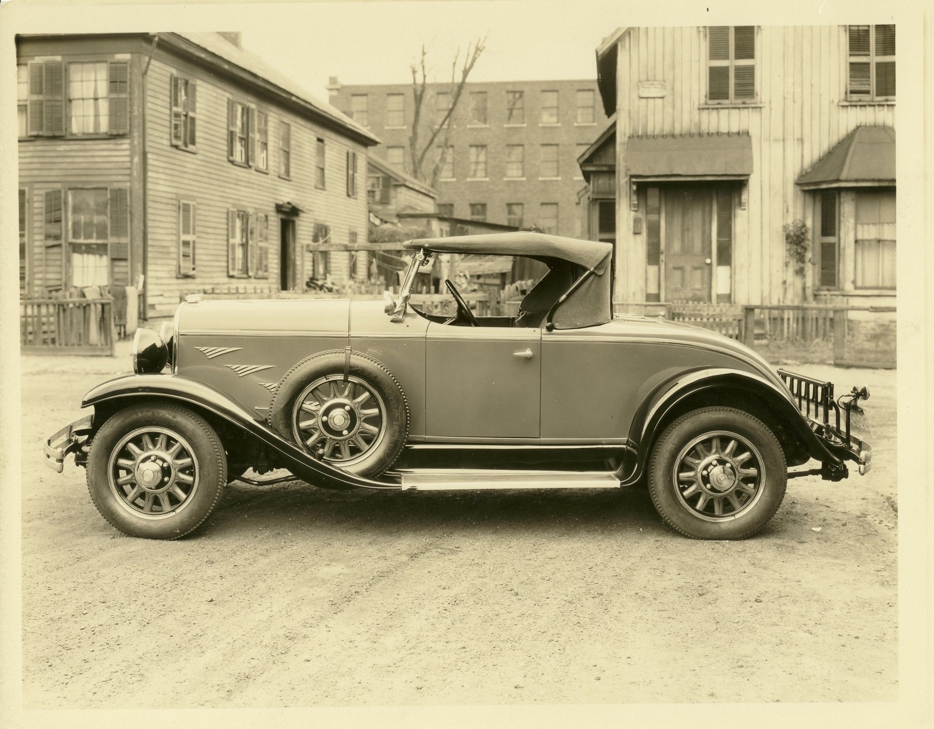 Sepia side view of a vintage Chrysler coupe parked on an early 20th-century street — 2K Quad HD PC desktop wallpaper and background.