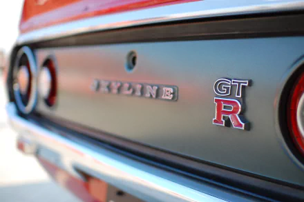 Close-up of the rear emblem on a Nissan Skyline GT-R, captured in high definition, serving as a sleek PC desktop wallpaper and background.
