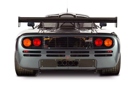 Rear view of a silver McLaren F1 with prominent exhausts and rear wing, showcased in 4K Ultra HD as a PC desktop wallpaper and background.