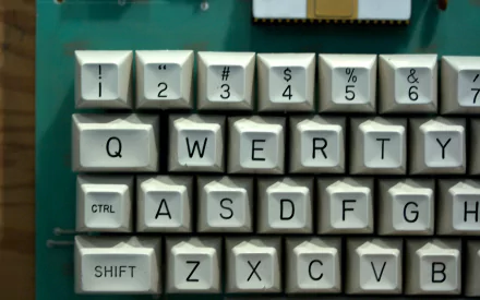 Close-up of a vintage computer keyboard featuring keys labeled with letters and symbols. This HD desktop wallpaper showcases a nostalgic technology theme.