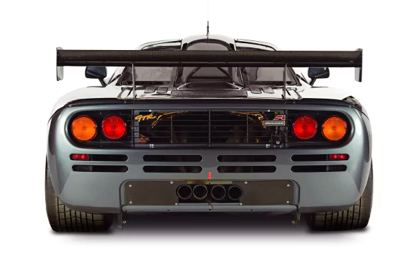 Rear view of a silver McLaren F1 with prominent exhausts and rear wing, showcased in 4K Ultra HD as a PC desktop wallpaper and background.