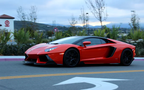 Red Lamborghini Aventador sports car on a street with trees and hills in the background, captured in 4K Ultra HD for PC desktop wallpaper.