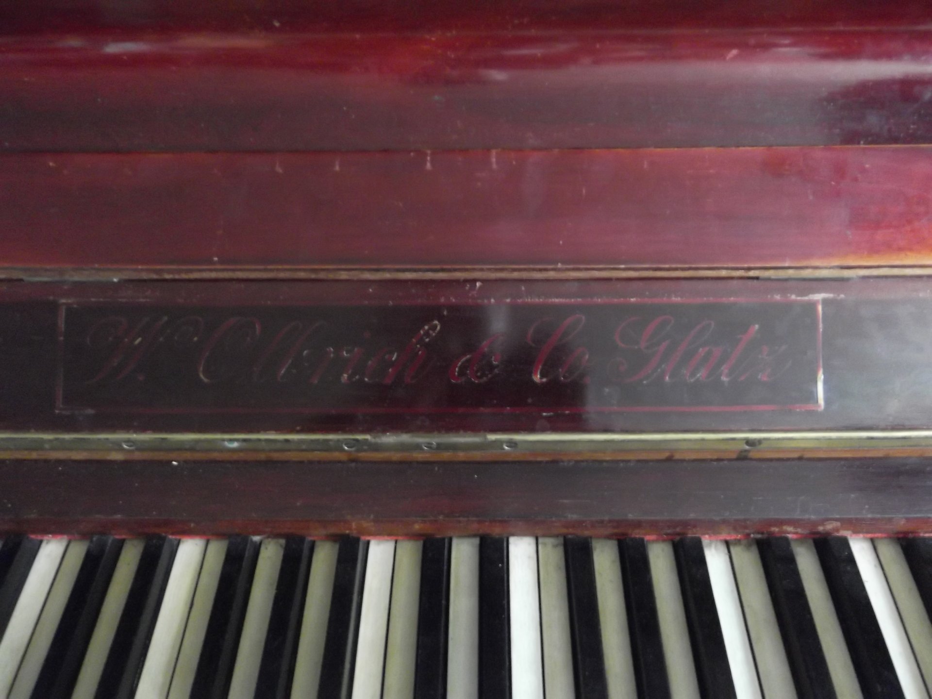 Music piano close-up showing a worn wooden nameplate and ivory keys — 4K Ultra HD PC desktop wallpaper and background.