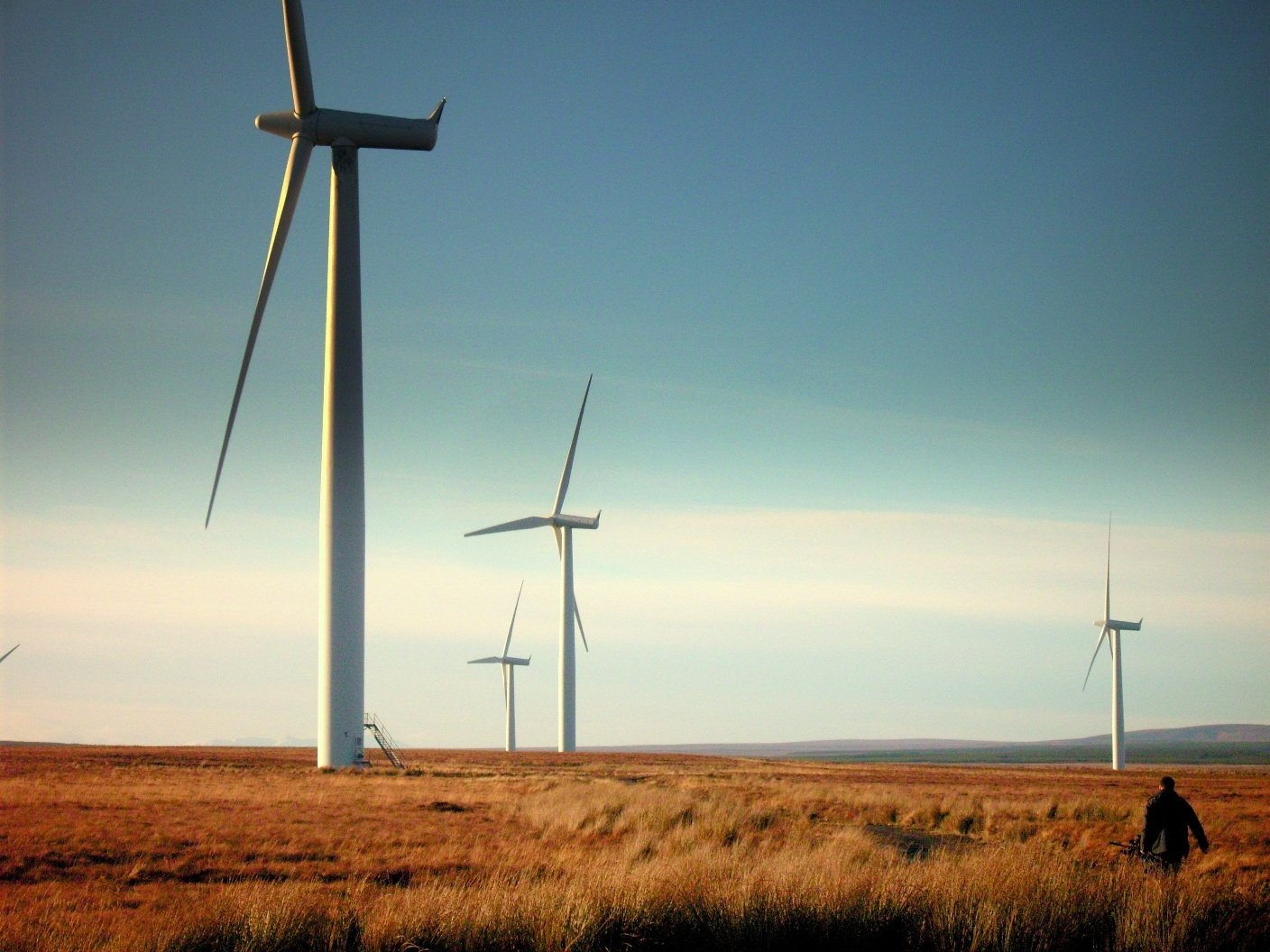 HD PC desktop wallpaper featuring man-made wind turbines set against a clear sky over a dry, open landscape.