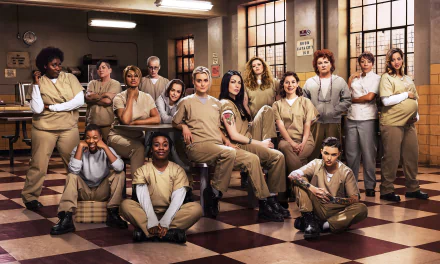 Cast of Orange Is the New Black poses together in prison uniforms, showcasing a diverse group of characters in a vibrant setting. HD desktop wallpaper features the ensemble in a dynamic arrangement.