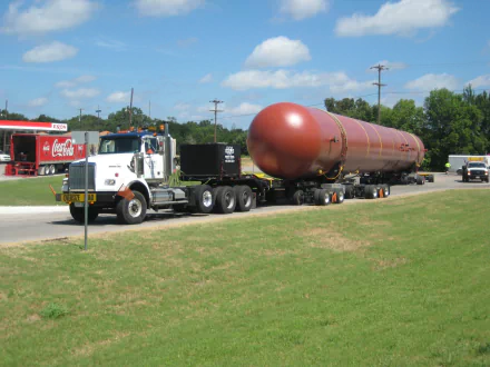 HD desktop wallpaper featuring a Western Star vehicle transporting a large cylindrical tank on a sunny day with a clear blue sky.