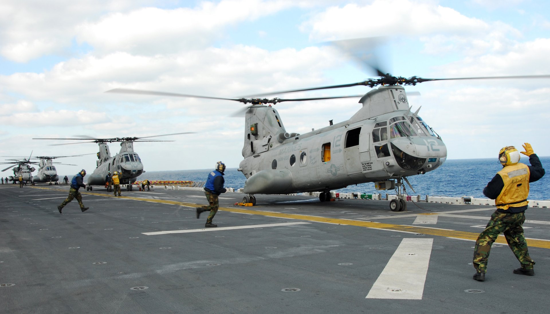 HD PC desktop wallpaper/background of military Boeing Vertol CH-46 Sea Knight helicopters on a ship deck with marines running to secure them.
