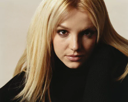 HD PC desktop wallpaper featuring a close-up of Britney Spears with a serious expression, highlighting her music career.