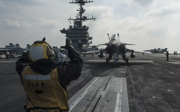 USS Harry S. Truman aircraft carrier with a Dassault Rafale jet preparing for takeoff on deck under a cloudy sky in this HD military wallpaper.