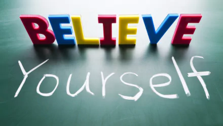 A vibrant motivational HD desktop wallpaper featuring colorful letters spelling BELIEVE on a chalkboard, with Yourself written beneath in white chalk.