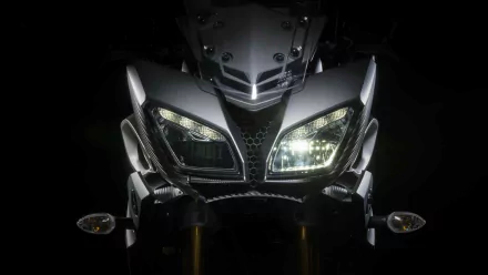 Close-up of a Yamaha MT-09 motorcycle front with illuminated headlights, showcased in a 4K Ultra HD PC desktop wallpaper background.
