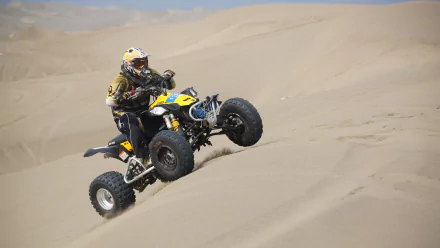 A rider on a yellow ATV motocross vehicle jumps over a sand dune, captured in sharp detail as a 4K Ultra HD PC desktop wallpaper.