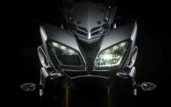 Close-up of a Yamaha MT-09 motorcycle front with illuminated headlights, showcased in a 4K Ultra HD PC desktop wallpaper background.