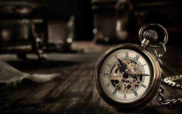 A vintage pocket watch with a detailed clock face sits elegantly on a dark wooden surface, showcasing its intricate design in this HD wallpaper and background.
