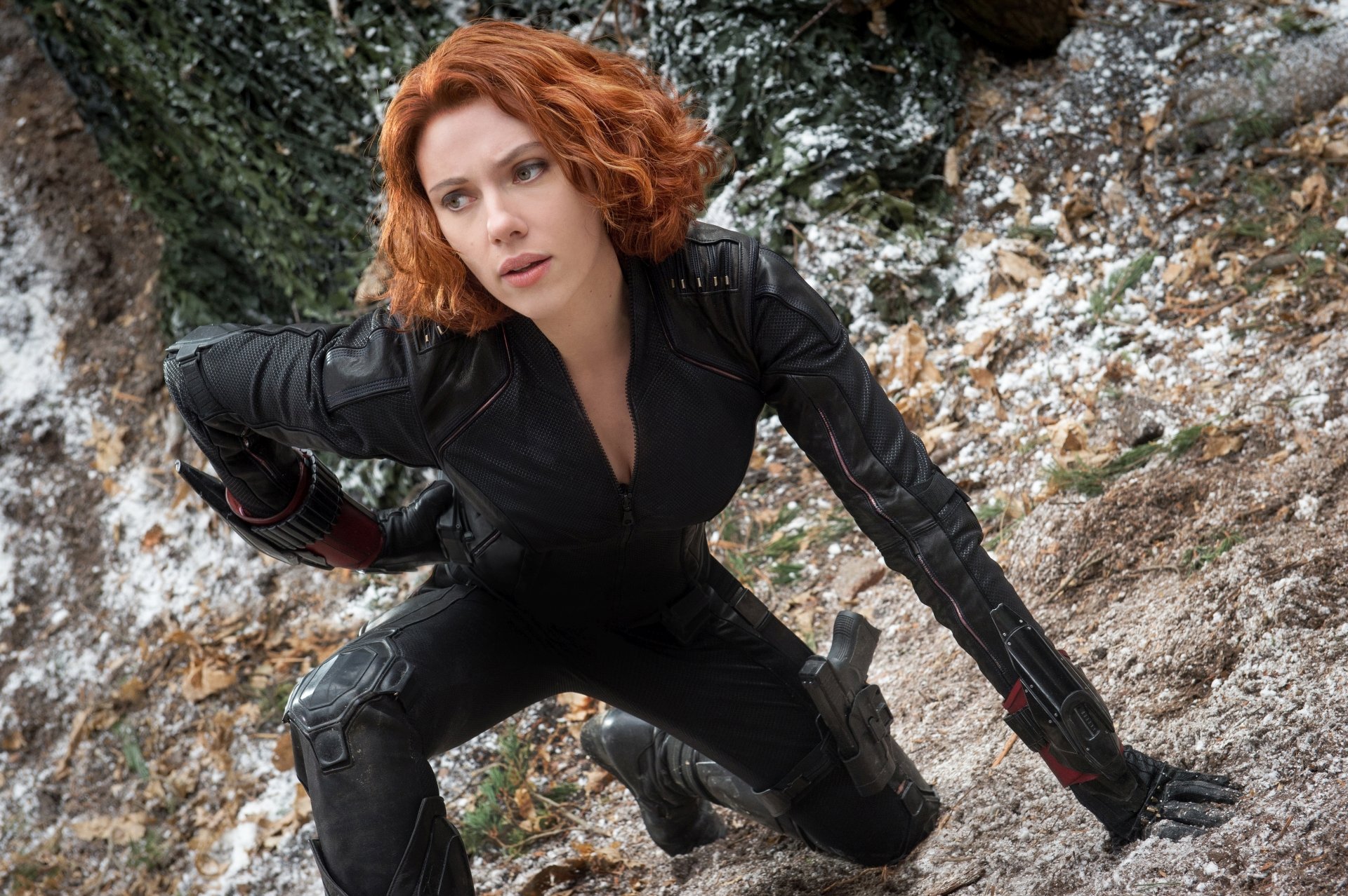 HD desktop wallpaper featuring Scarlett Johansson as Black Widow with red hair in 'Avengers: Age of Ultron,' poised in a dynamic action scene amidst a snowy and rocky landscape.