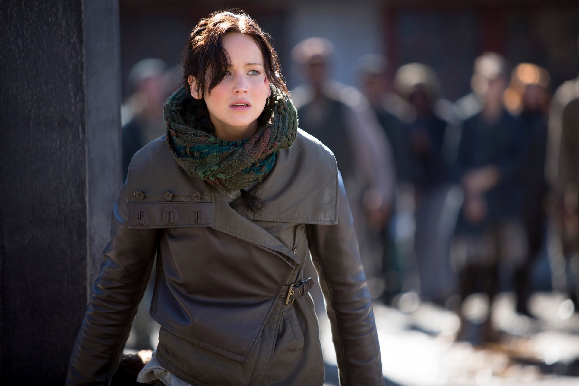 Character in a battle-worn coat from The Hunger Games: Mockingjay - Part 2, intense outdoor scene, 5K Ultra HD PC desktop wallpaper.