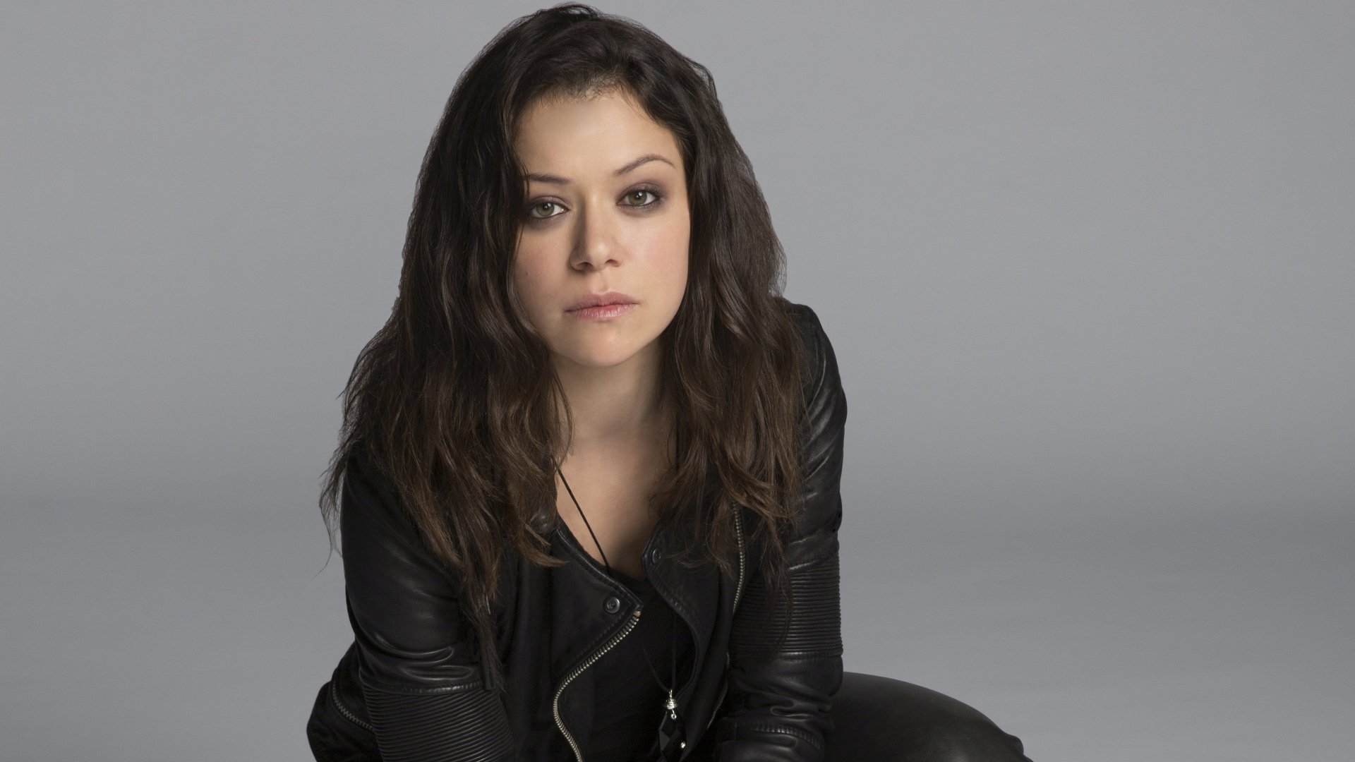 4K Ultra HD PC desktop wallpaper from the TV show Orphan Black: solitary woman in a black leather jacket against a neutral gray backdrop, intense, moody expression.