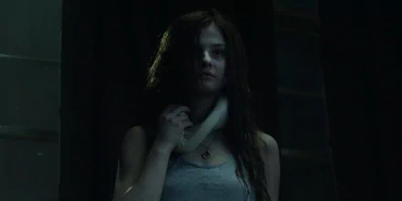 A dramatic HD wallpaper featuring Stefanie Scott in a scene from Insidious: Chapter 3, highlighting her intense expression and haunting atmosphere.