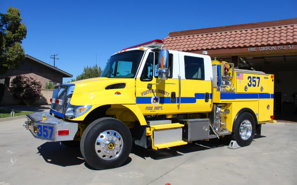 Yellow International fire truck (Engine 357) parked outside a station under a clear blue sky — 4K Ultra HD PC desktop wallpaper/background, vehicle