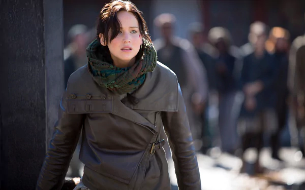 Character in a battle-worn coat from The Hunger Games: Mockingjay - Part 2, intense outdoor scene, 5K Ultra HD PC desktop wallpaper.